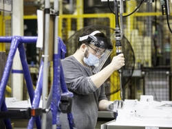 A GE Appliances employee wearing advanced personal protective equipment works the assembly line. A GE Appliances employee wearing advanced personal protective equipment works the assembly line.