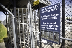 Instructional signage is posted at entrances on touchless turnstile entry.