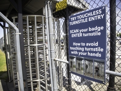 Instructional signage is posted at entrances on touchless turnstile entry.