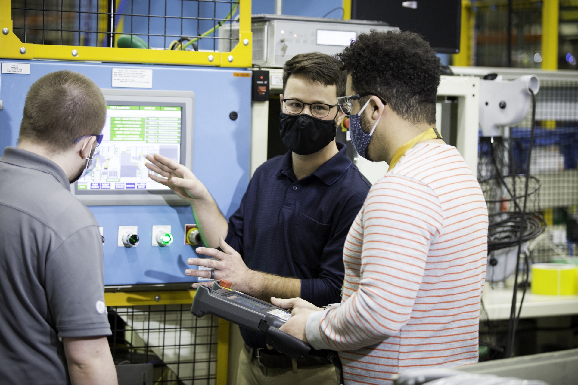 Collie Crawford, the first graduate of GE Appliances’ Industry 4.0 Development Program, talks through the operator station interface with other engineers in the program.