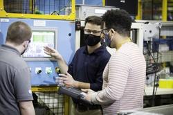 Collie Crawford, the first graduate of GE Appliances’ Industry 4.0 Development Program, talks through the operator station interface with other engineers in the program.
