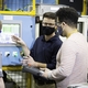 Collie Crawford, the first graduate of GE Appliances’ Industry 4.0 Development Program, talks through the operator station interface with other engineers in the program.