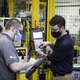 Two employees on GE Appliances’ Industry 4.0 Development Program – Jordan Klotz (left) and Collie Crawford (right) – discuss short cuts for “pick and place” routines on the robot teach pendant for the new automated dishwasher spray arm assembly cell.