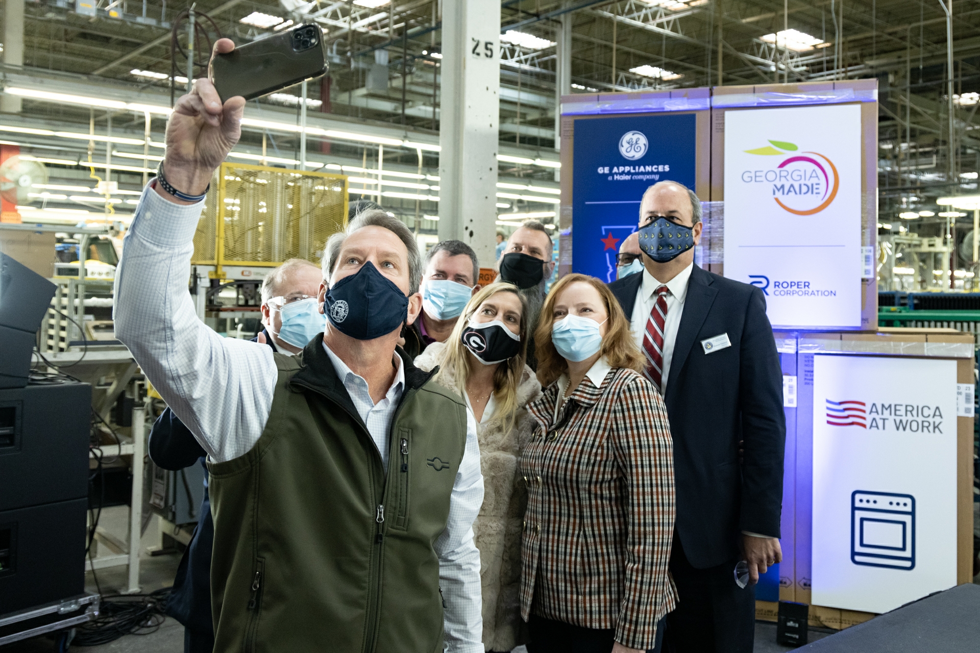 Georgia Governor Brian Kemp, First Lady Marty Kemp, and Roper Corporation President Lois Crandell  pose for a selfie with other government officials