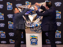 Todd Getz, executive brand director for GE Appliances and Alex Sotiropoulos, brand manager for Pop-Tarts unveil the 2024 Pop-Tarts Bowl Trophy.