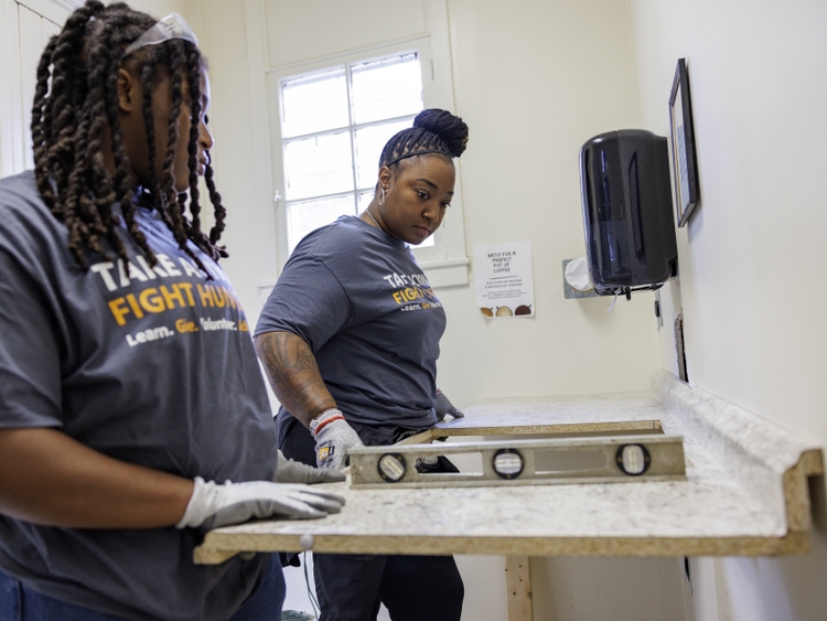 GE Appliances employees measuring and leveling countertops during Hunger Action Month.