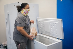 GE Appliances employees placing donated frozen food into a community freezer to support local families.