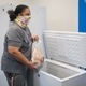 GE Appliances employees placing donated frozen food into a community freezer to support local families.