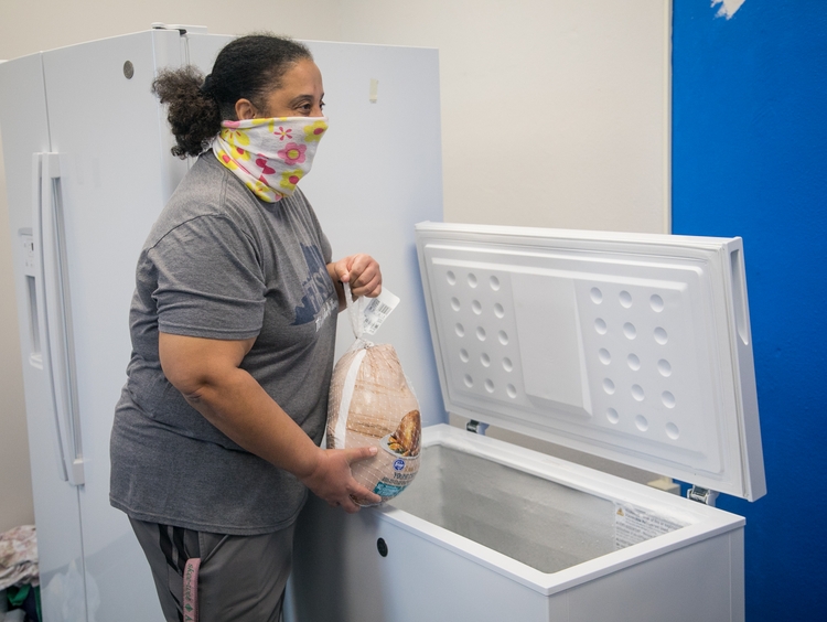 GE Appliances employees placing donated frozen food into a community freezer to support local families.