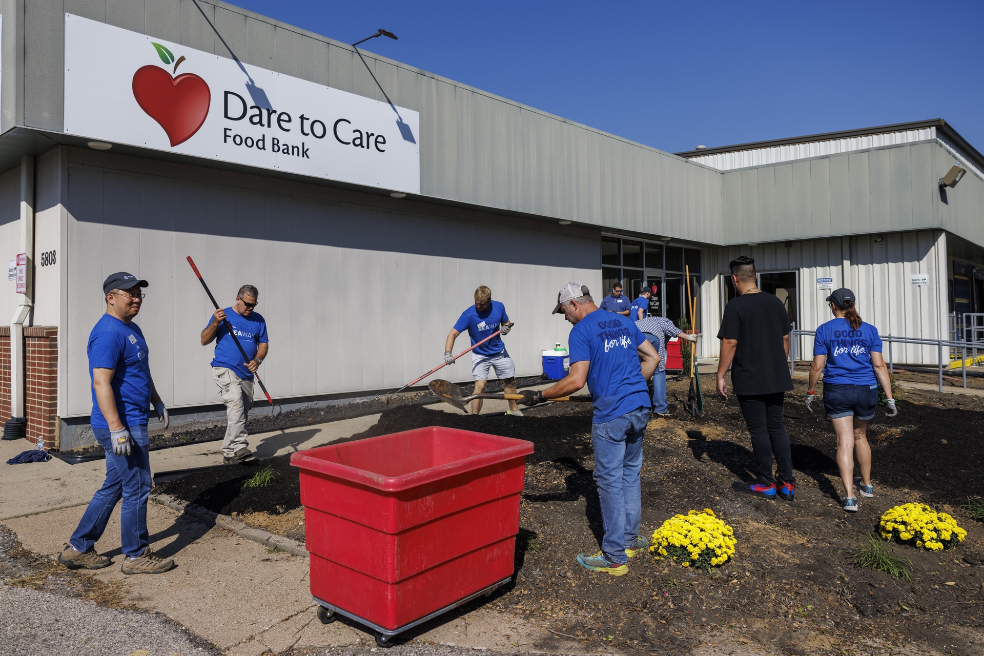 GE Appliances employees volunteering at Dare to Care Food Bank by landscaping and improving the outdoor space.