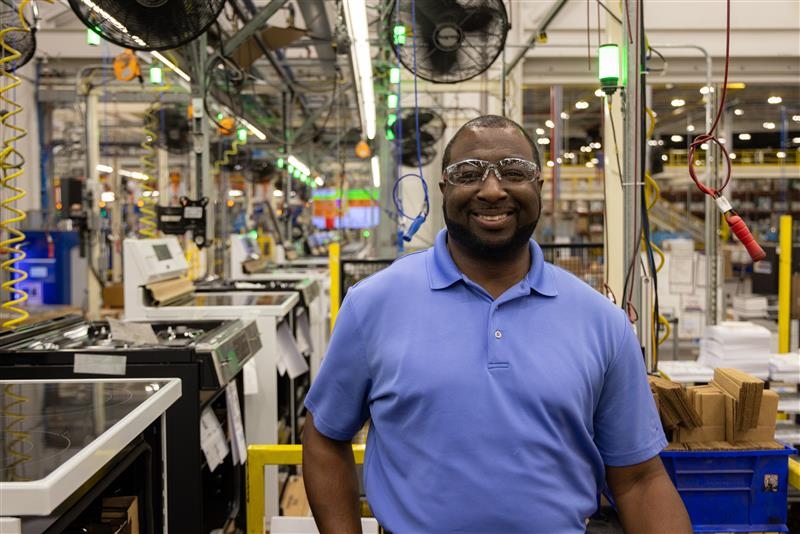 Executive Director and Plant Manager at Roper Corporation, a wholly owned subsidiary of GE Appliances in LaFayette, GA, stands next to one of two new high-volume range manufacturing lines that can produce electric, gas or the new, more affordable induction ranges the company launched this year.