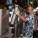 A team member at the GE Appliances Decatur AL plant installs components on a top freezer refrigerator.