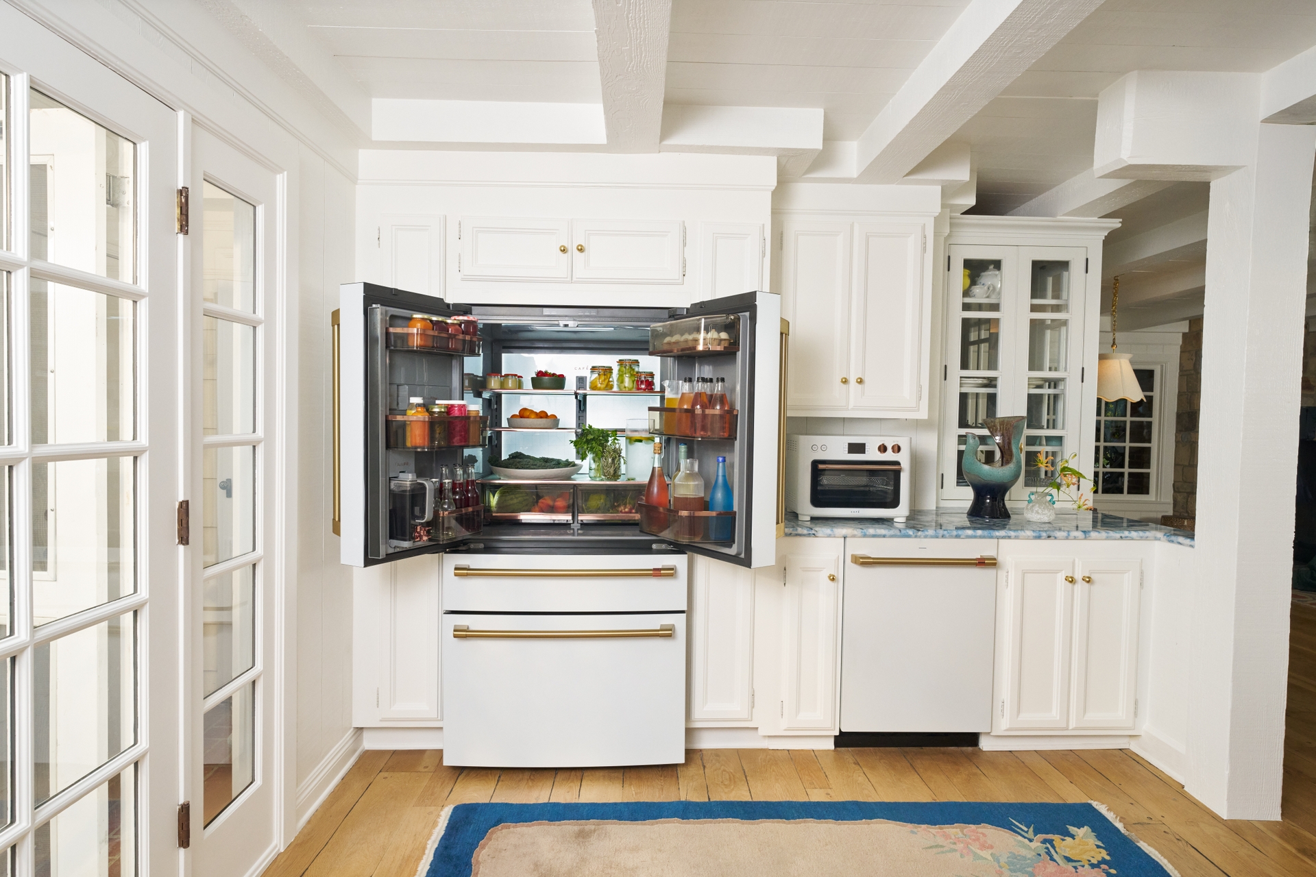  CAFÉ's 4-Door French-Door Refrigerator with Dual Dispense AutoFill Pitcher next to Kates CAFÉ Couture Toaster Oven with Air Fry and CAFÉ CustomFit Dishwasher