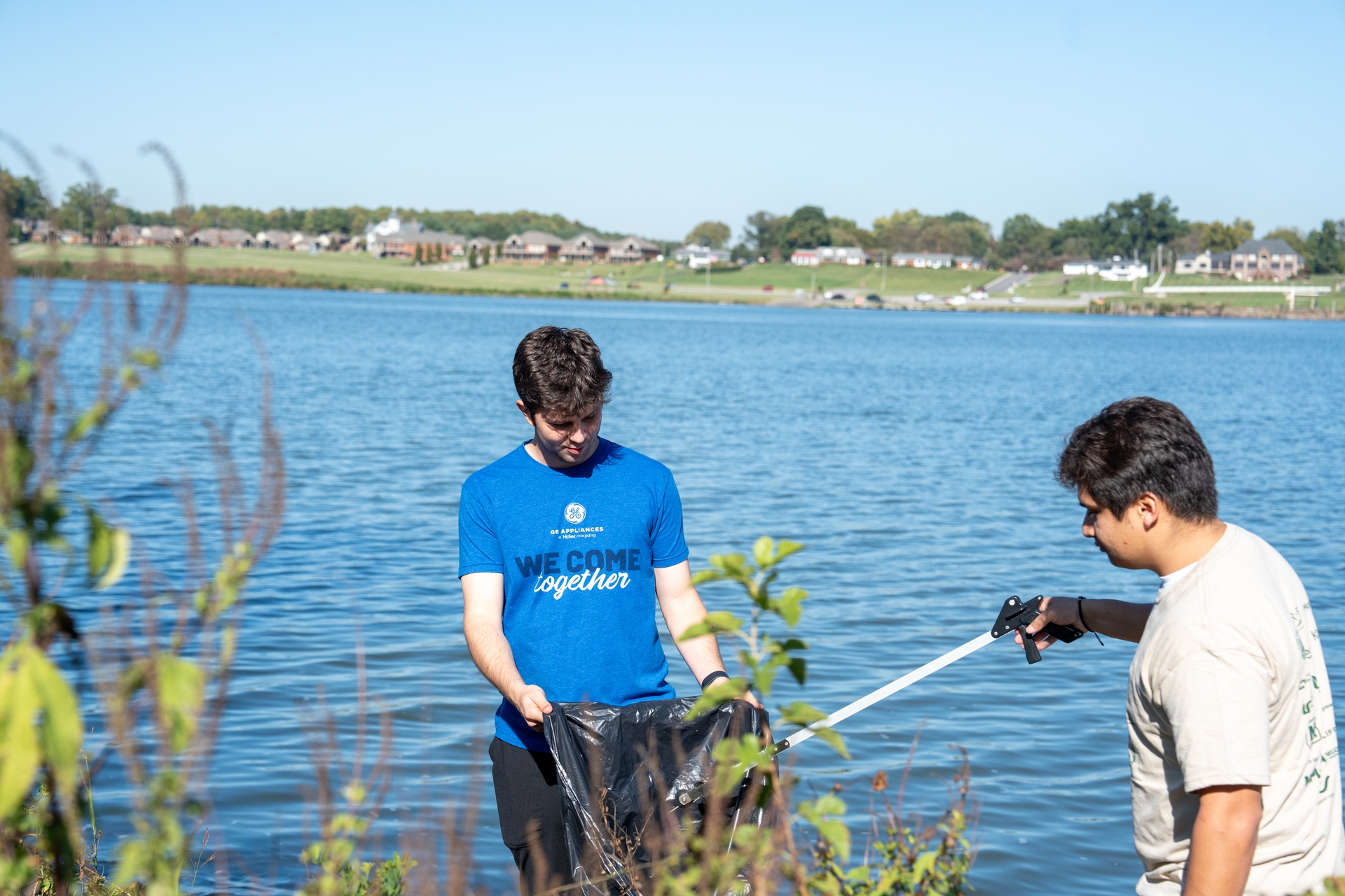 Volunteers clean up the banks of the Ohio River by removing trash and cleaning shared spaces.