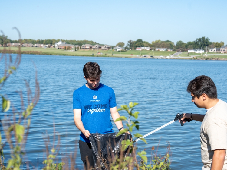 Volunteers clean up the banks of the Ohio River by removing trash and cleaning shared spaces.