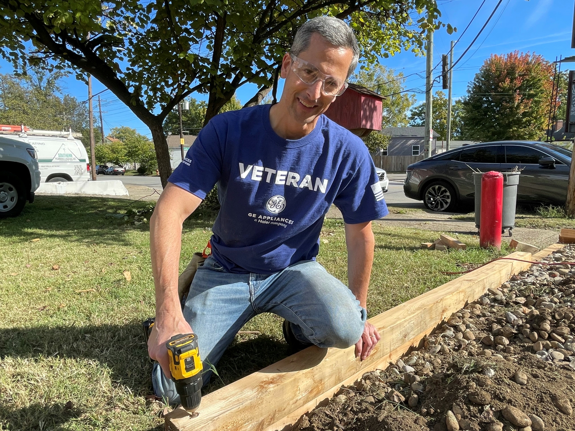 A GE Appliances employee and veteran volunteer installs new landscaping borders.