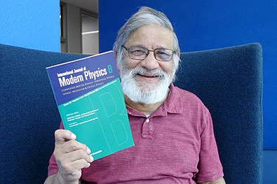 Vasudev "Nitant" Kenkre smiles proudly with a copy of the Festschrift in his honor. Festschrift cover