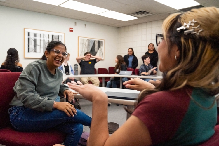 ASL students laugh during a conversation in signed language.