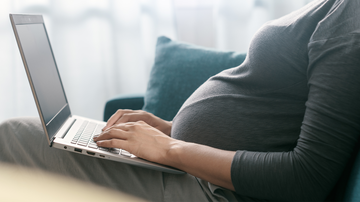 Expecting mother working on her laptop