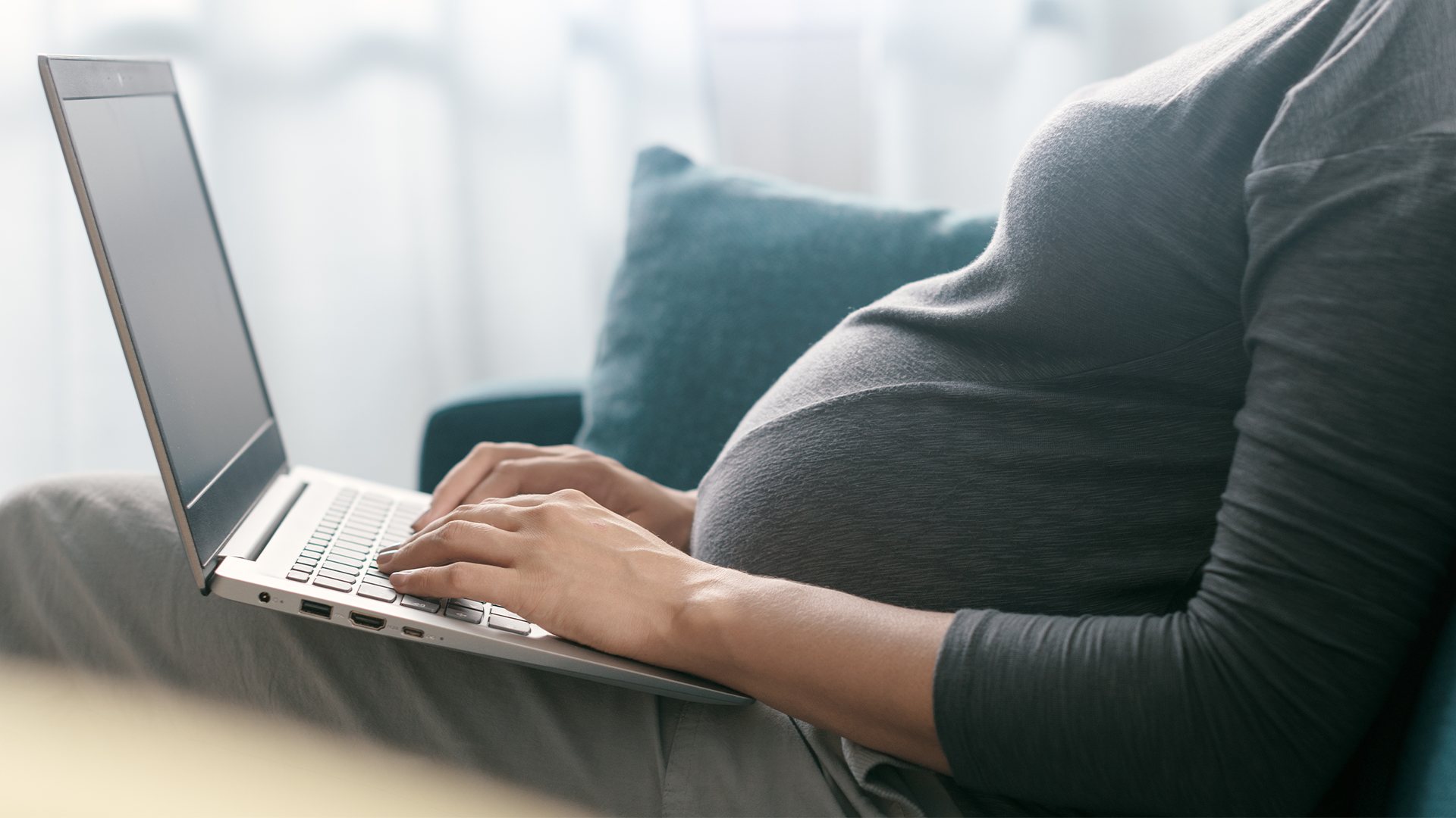 Expecting mother working on a laptop. Expecting mother working on her laptop