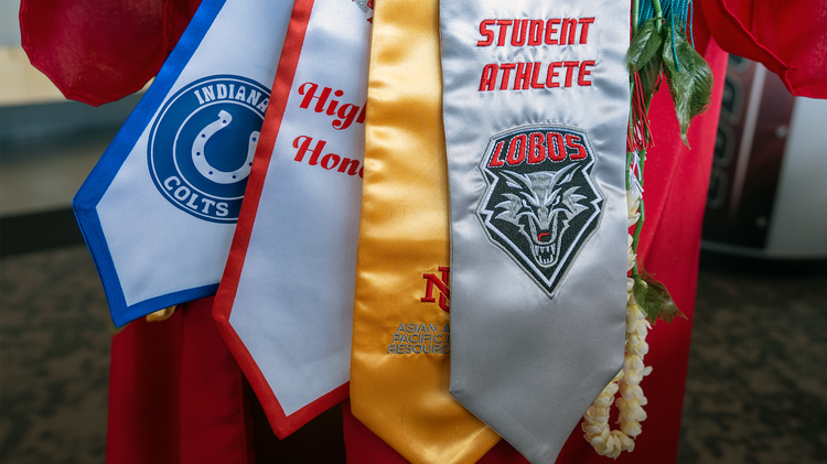 Malia Dumlao displaying several graduation stoles