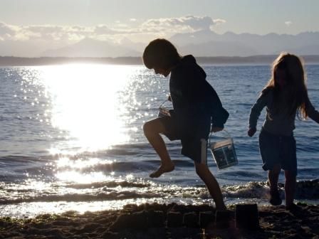 little kids play in sand at beach