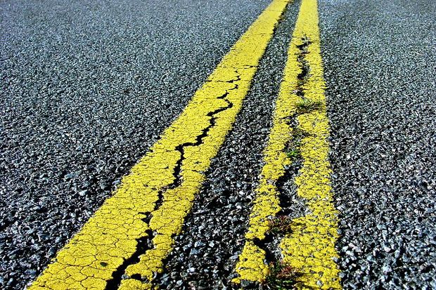 double yellow road line with cracks