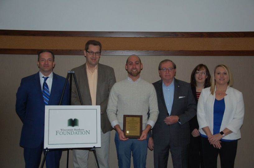 Christopher Piotrowski (left) and Steven Landwehr (center), corporate social responsibility analyst, Associated Bank, pictured with WBF board members at the Excellence in Financial Education awards event. 