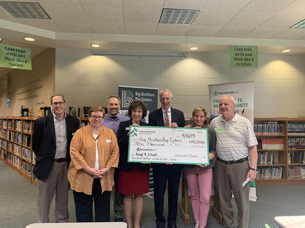 Denis Hogan (center) presented a $10,000 check to Big Brothers Big Sisters of Northeast Wisconsin in support of new Adopt-A-School program.