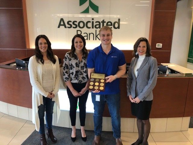 Jane Lowe from the American Heart Association (second from left) presents the award to Melissa Karls, Arthur Valentine and Angie DeWitt of Associated Bank.