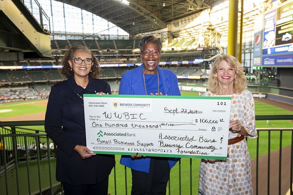 LaDonna Reed, Associated Bank and Cecelia Gore, Brewers Community Foundation, present a $100K check to Wendy Baumann of WWBIC to support minority, women and veteran owned businesses