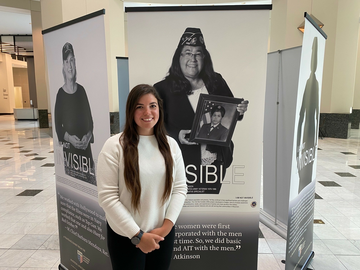 Bonnie Atkinson with Associated Bank stands next to a photo of her mother, Julia Atkinson 