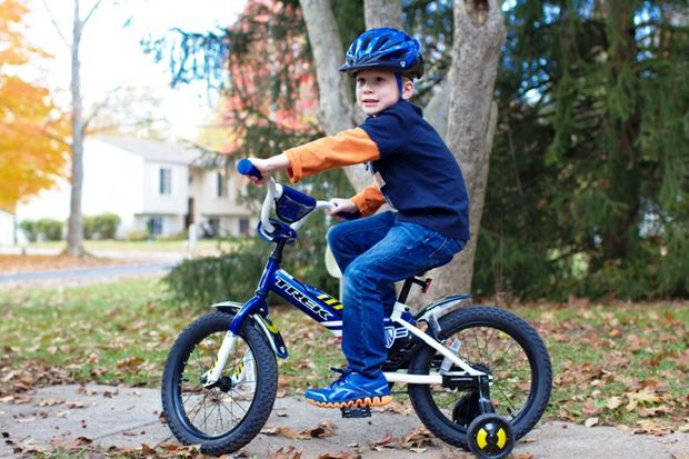 boy with training wheels bike helmet