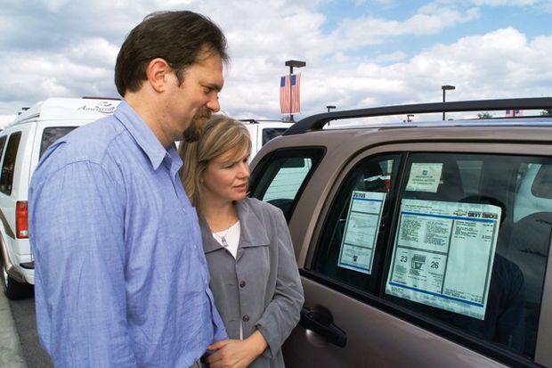 couple looks at mileage sticker
