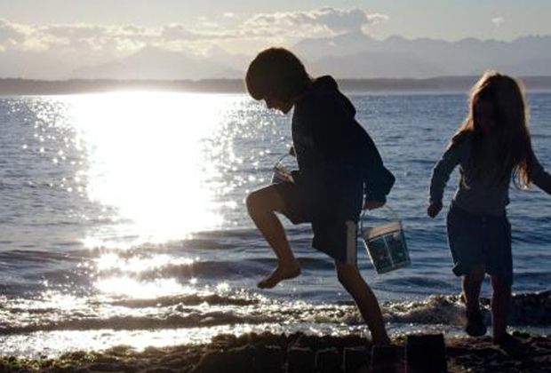 little kids play in sand at beach copy