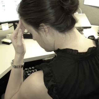 A woman appearing stressed out at her work deskcopyright American Heart Association