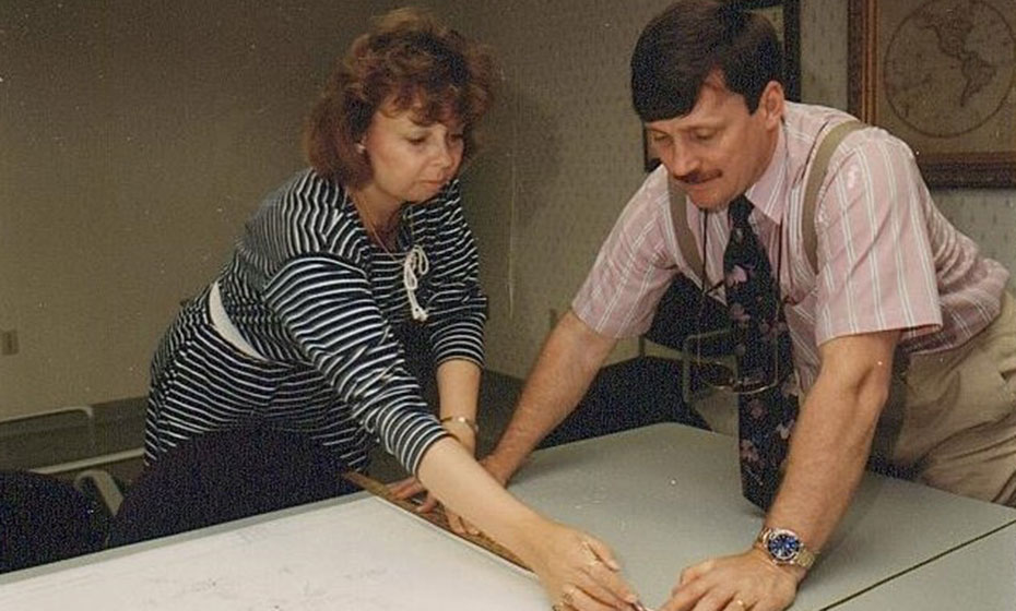 A woman, left, and a man, right, look over a map.