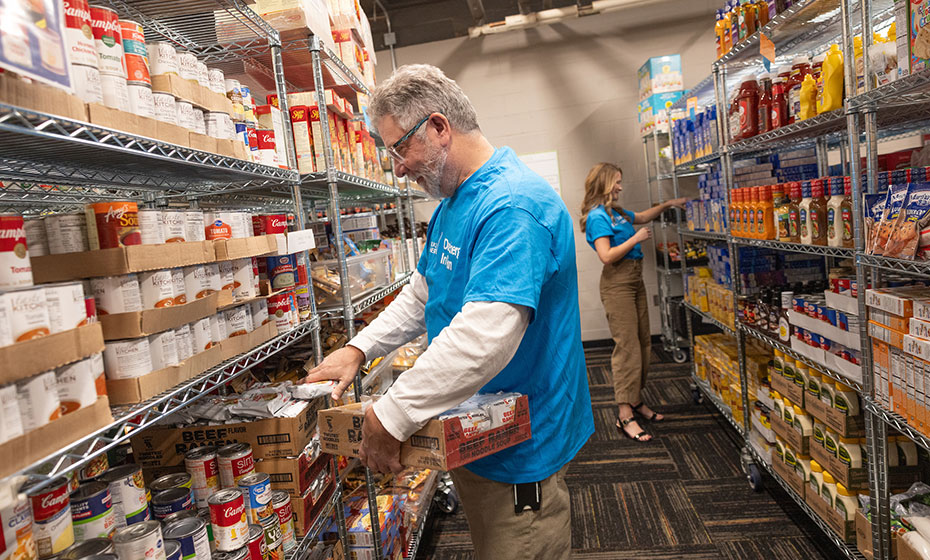 Volunteers from Duke Energy help stock the shelves at an Indiana food pantry with canned goods and other items.