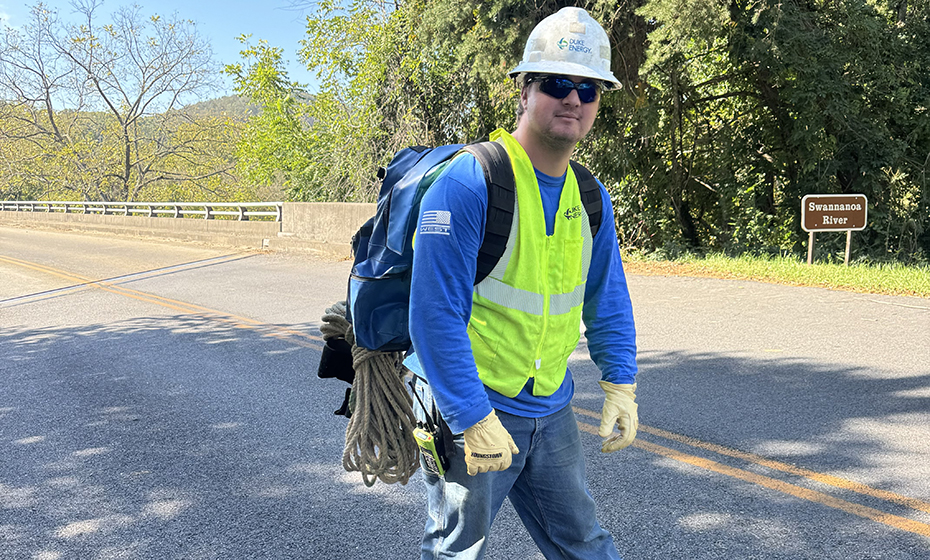Apprentice lineworker Nathan Curlee strapped gear to his back to prepare for the hike to the VA hospital