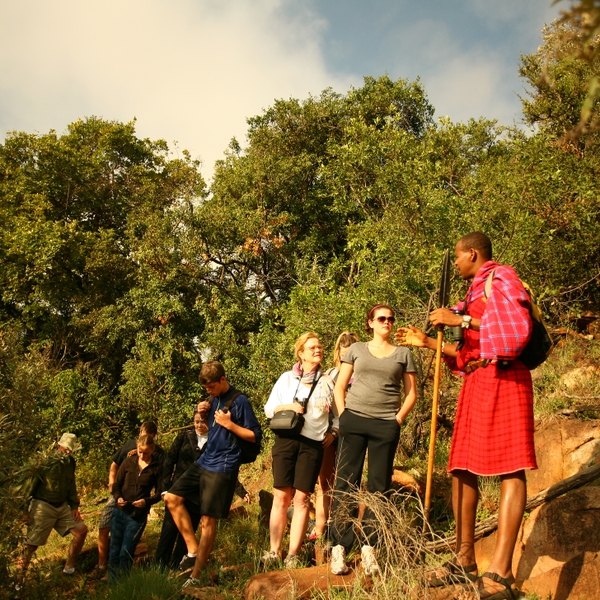 Specialty guide Jackson Looseyia explains Maasai culture to young travelers in Kenya.