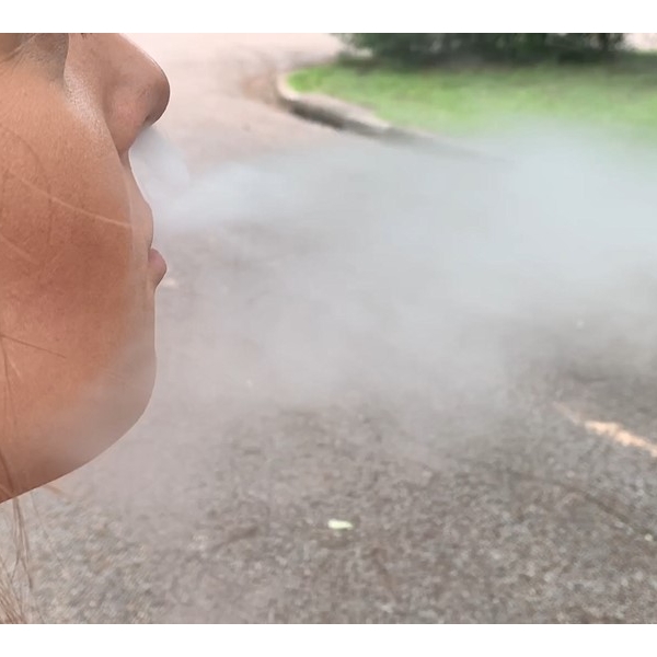 Woman+blowing+e-cigarette+smoke