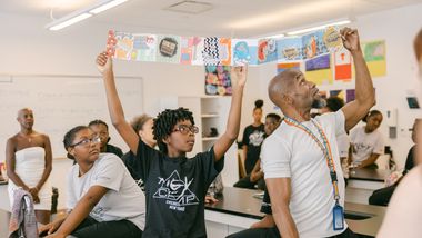 AileyCamp New York Director Damazi Williams with participants showcasing artwork in Creative Communications class