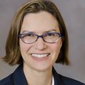 Close-in head shot of Alison Edelman, M.D., M.P.H., a smiling adult wearing glasses.
