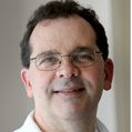 Close-in headshot of John Brigande, Ph.D., a dark-haired male wearing glasses
