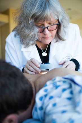Sancy Leachman, M.D., Ph.D., performs a skin check.