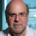 Sadik Esener, Ph.D., tiene cabello corto, escaso y oscuro, anteojos y vello facial gris claro, y viste ropa profesional. Sentado seriamente en una habitación del Knight Cancer Institute.