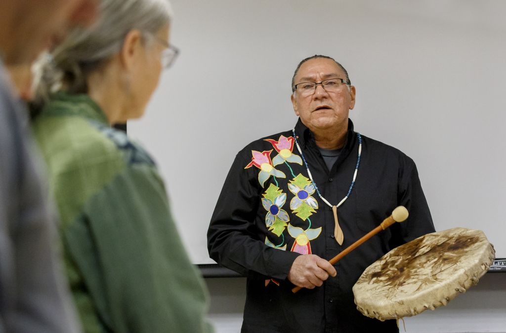 a Native American physician plays hand drum and sings