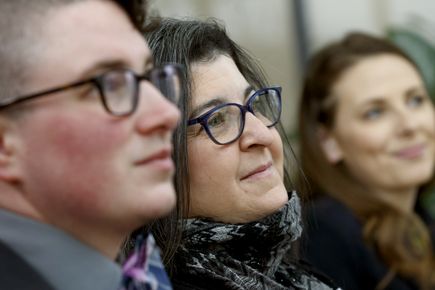 three people smiling, listening