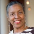 African-american woman with very short hair, smiling, looking at camera
