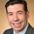 man, smiling at camera, wearing a suit coat 
